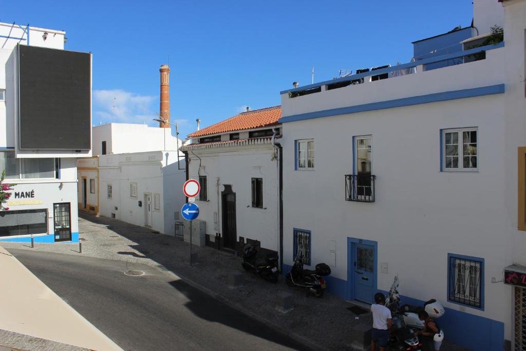 an alley with white buildings and people standing on a street at Casa Pérola, Old Town Apartment in Albufeira