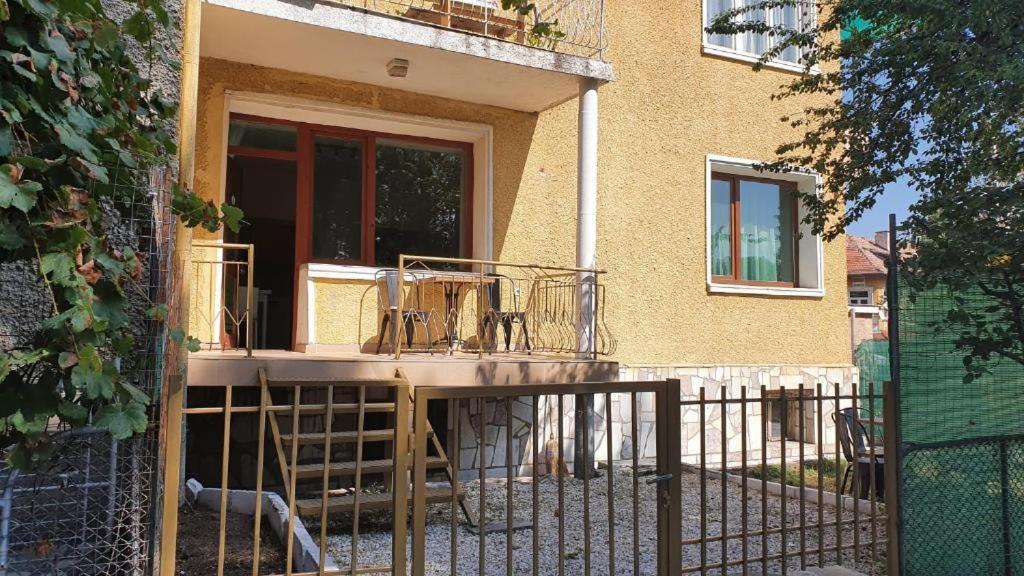 een veranda aan de voorzijde van een huis met een hek bij Ваканция in Velingrad