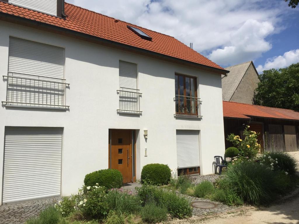 une maison blanche avec un toit rouge dans l'établissement Sonniges Jura Loft im Golf Paradies Hilzhofen, à Pilsach