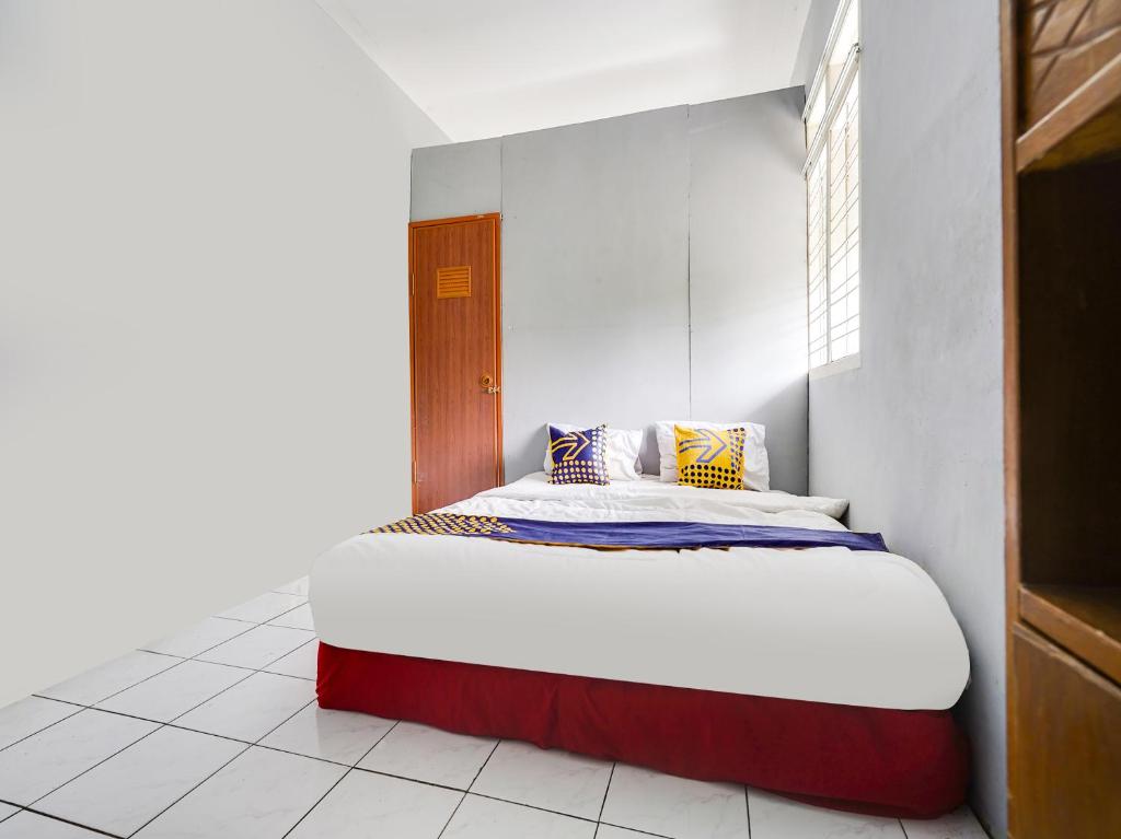 a bedroom with a large bed in a room at SPOT ON 91393 Budiluhur 10 Homestay in Bandung