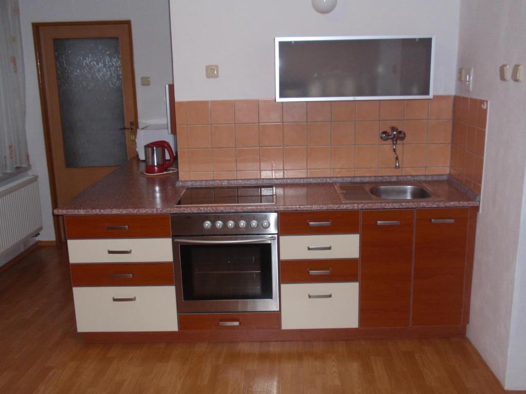 a small kitchen with a stove and a sink at Apartmán Janoušek in Humpolec