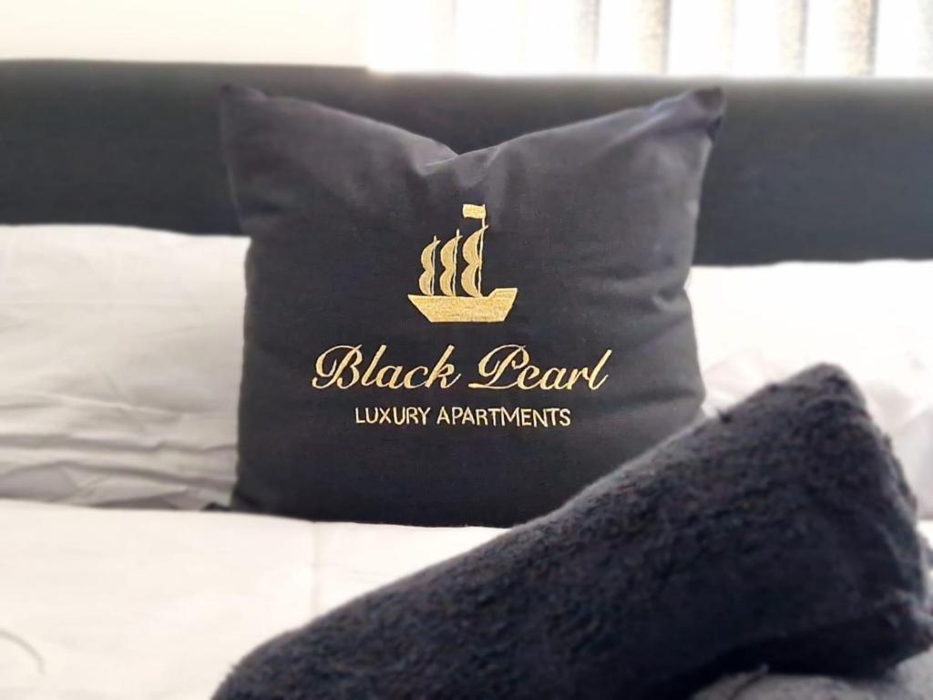 a black pearl pillow sitting on top of a bed at Black Pearl Luxury Apartments in Blackpool