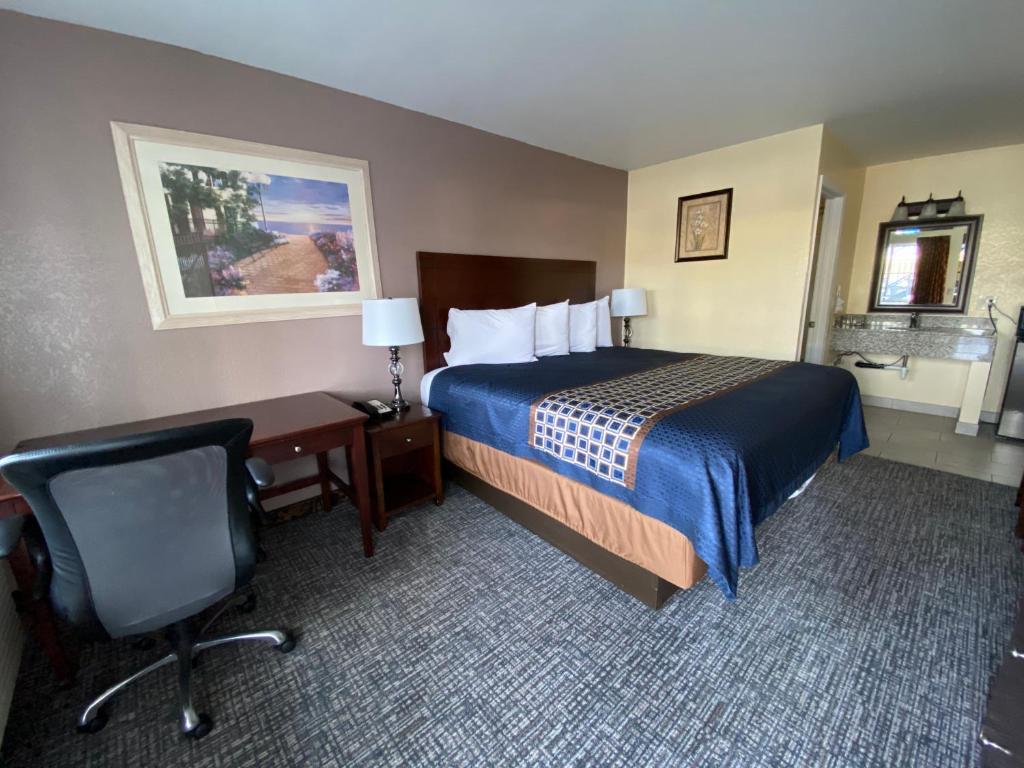 Habitación de hotel con cama, escritorio y silla en Beachway Inn en Arroyo Grande