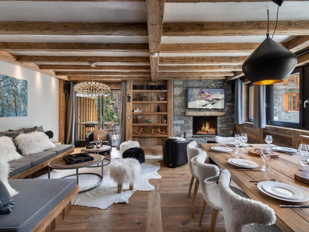 un salon avec une table et une cheminée dans l'établissement Appartement luxueux avec spa nordique et hammam au cœur de Val d'Isère - FR-1-567-6, à Val dʼIsère