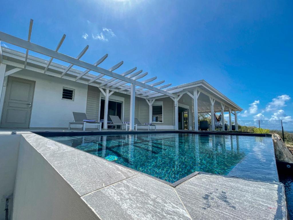 - une piscine avec pergola sur une maison dans l'établissement Magnifique Villa Standing vue mer et proche plage, à Saint-François