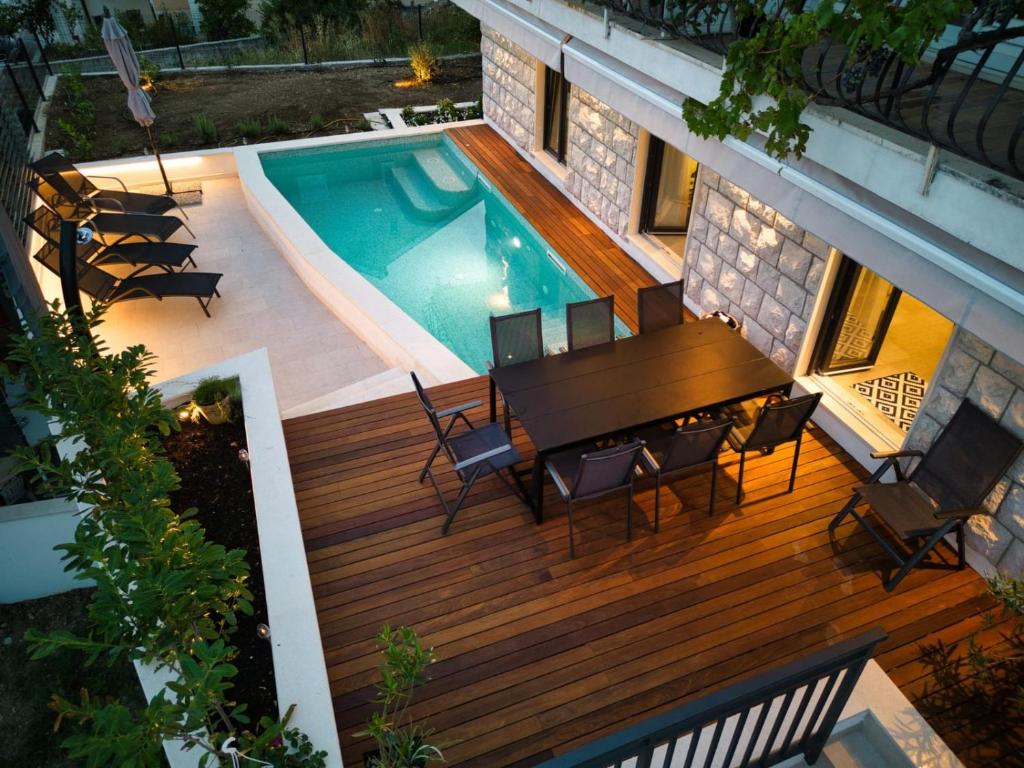 einen Blick über eine Terrasse mit einem Tisch und einem Pool in der Unterkunft Villa Nika with private heated pool in Slano