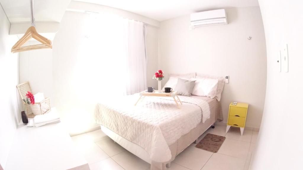 um quarto branco com uma cama e uma janela em Praia e Sol Apto a 3 quadras do Bessa Beach. em João Pessoa