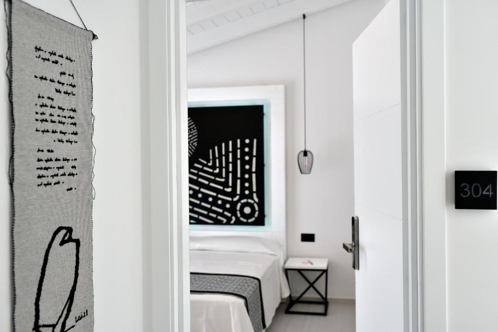 a bedroom with a bed and a black and white painting at Cara a Bentu - Charming Rooms in Tortolì