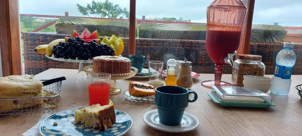 una mesa cubierta con platos de comida y bebida en Cabanas Bouganville, en Monte das Gameleiras