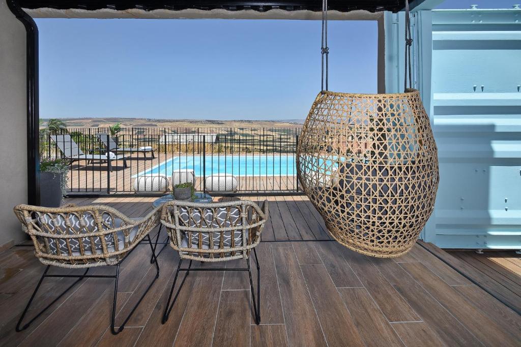 een patio met een tafel en stoelen en een grote vaas bij The Container luxury holiday resort for Couples in Yavneʼel
