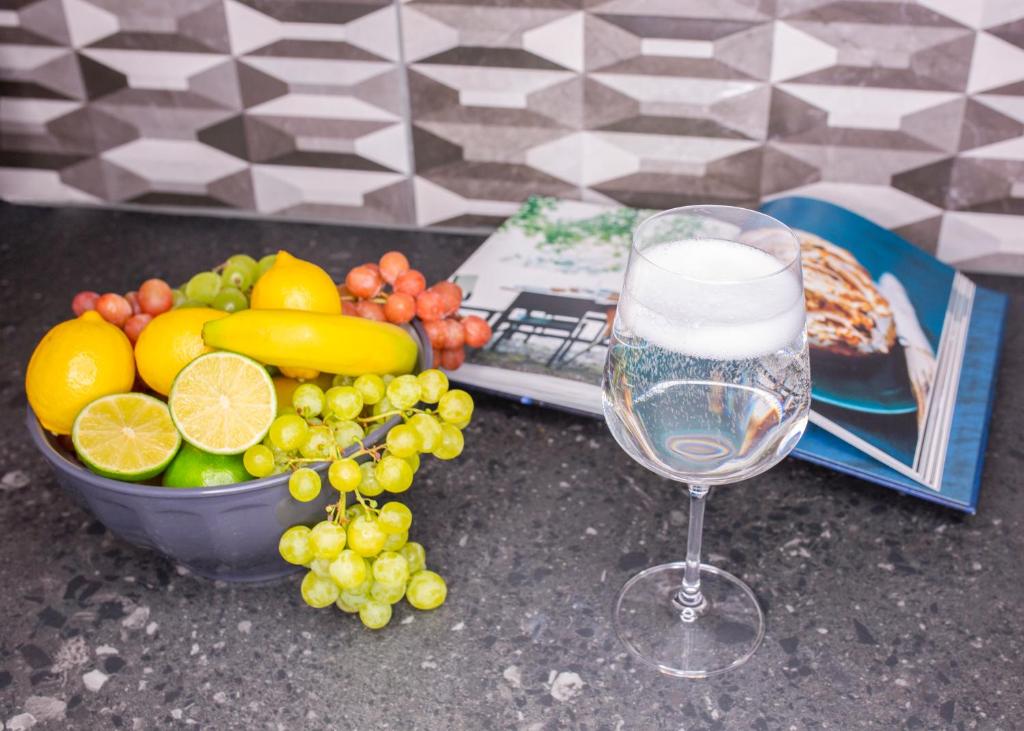 a glass of water next to a bowl of fruit at Charming Accommodation close to Birmingham in West Bromwich