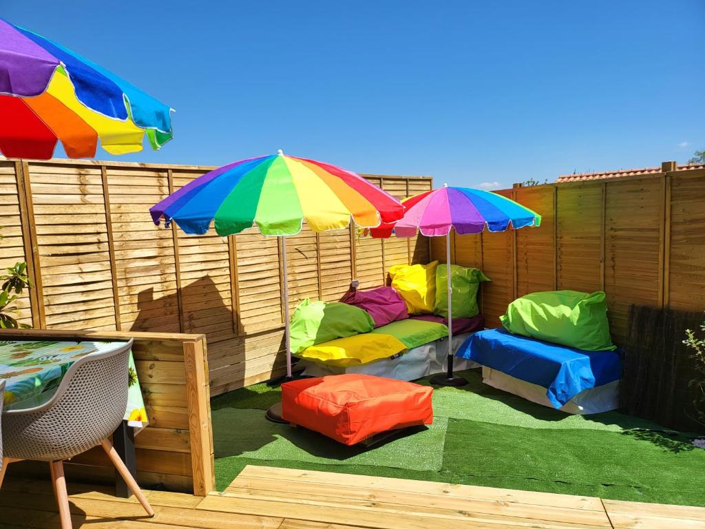 a group of chairs and umbrellas on a patio at ESCALE OCEAN A 800 m DE LA PLAGE in Notre-Dame-de-Monts