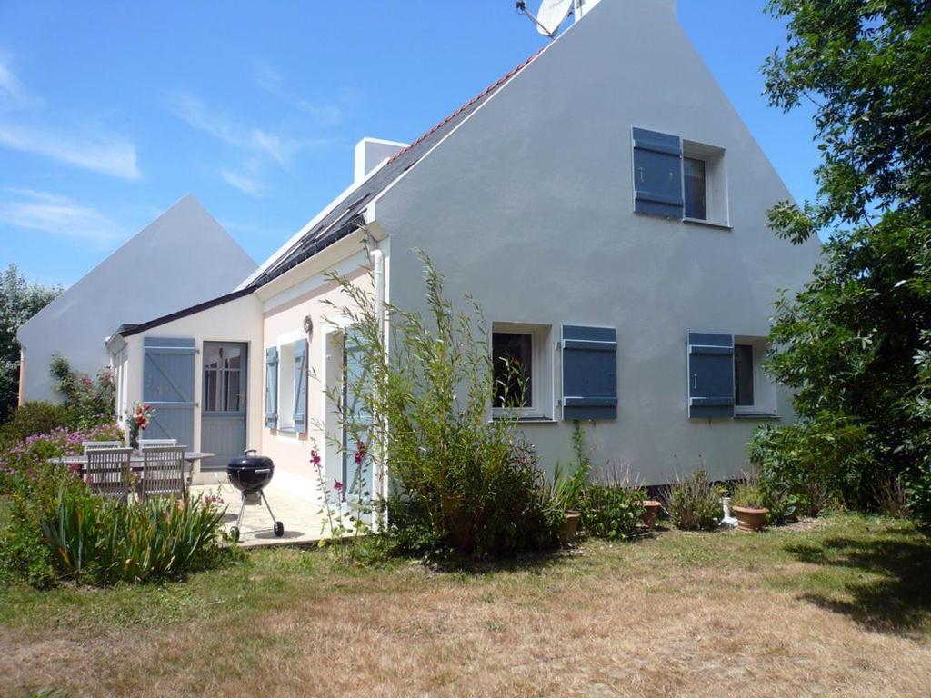 une maison blanche avec des fenêtres bleues et une cour dans l'établissement Maison Sauzon, 5 pièces, 6 personnes - FR-1-418-82, à Sauzon