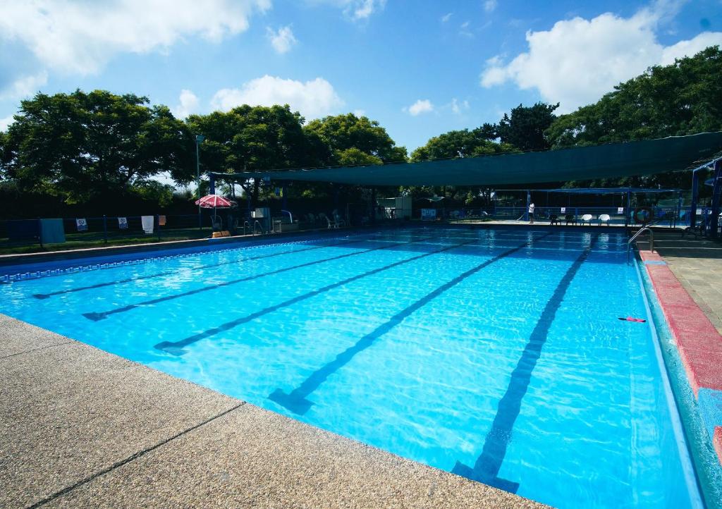 a large swimming pool with blue water at Mantur West Galilee by Selina in Loẖame HaGetaʼot