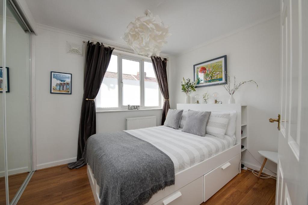 a white bedroom with a bed and a window at Tranquility Nook in Portsmouth