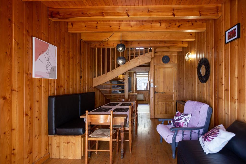 ein Wohnzimmer mit einem Esstisch und einem TV in der Unterkunft La Cabane du Petit Tour in Langogne