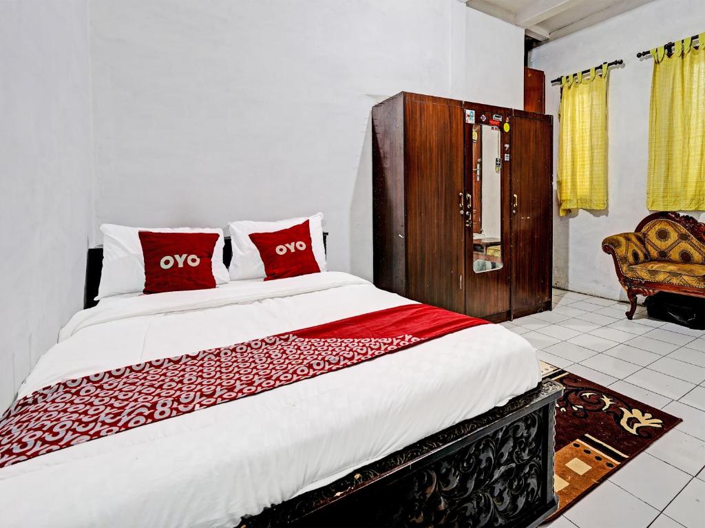 LebakwangiにあるOYO 91389 Anggrek Residence Syariahのベッドルーム1室(大型ベッド1台、赤い枕付)
