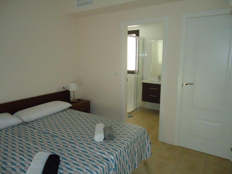 a bedroom with a bed and a door to a bathroom at Casa Patrick in Murcia