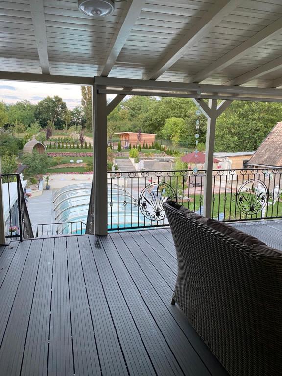 a porch with two chairs and a view of a pool at Maria Vendéghaz in Mernye