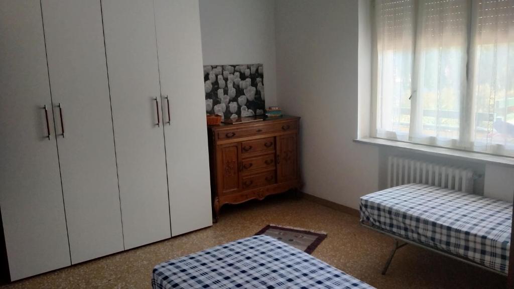 Zimmer mit weißen Schränken, einem Bett und einem Fenster in der Unterkunft Relax al mare in Silvi Paese