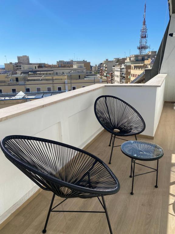 2 stoelen op een balkon met uitzicht op de stad bij 7th floor apartment in Foggia