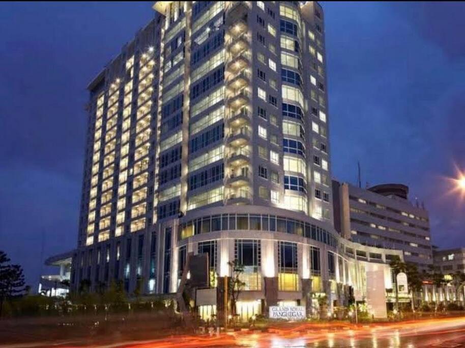 een groot gebouw 's nachts met verkeer voor de deur bij Two Bedroom Apartment at el Royale Hotel in Bandung