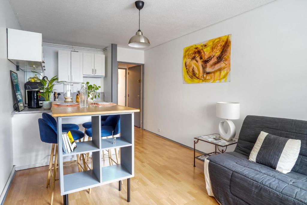 a kitchen and living room with a couch and a table at Superb apartment with parking & terrace in Bordeaux center - Welkeys in Bordeaux