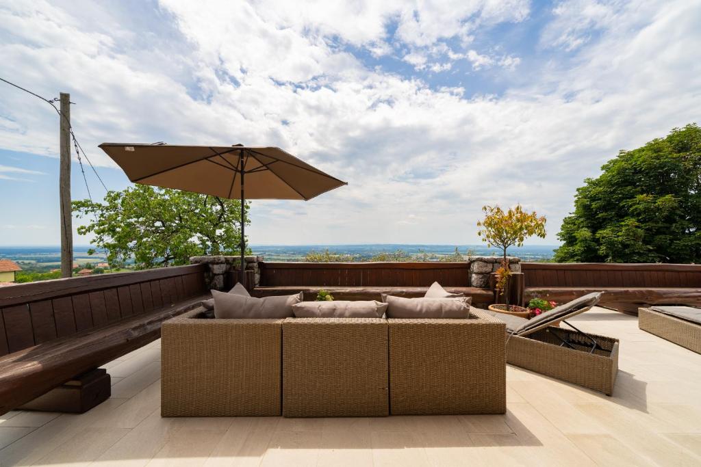 un patio con sombrilla y algunas sillas y mesas. en Hiša vina Cuk, en Lendava