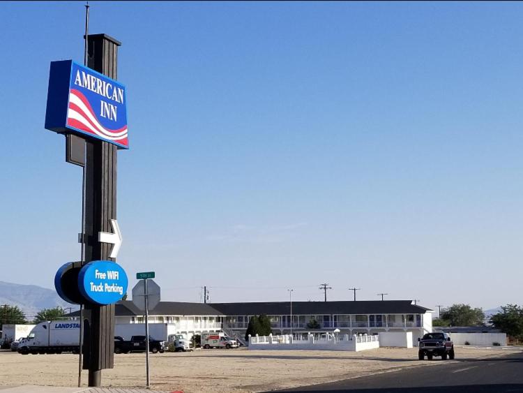 un letrero de una posada americana delante de un estacionamiento en American Inn, en Hawthorne