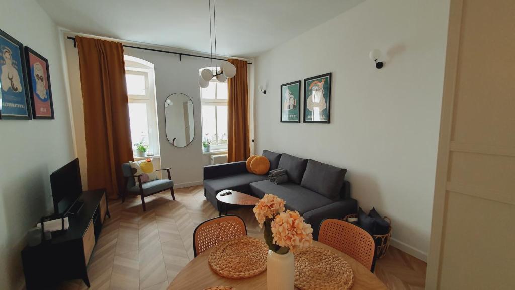 - un salon avec un canapé et une table dans l'établissement Kurkowa Apartment, à Wrocław