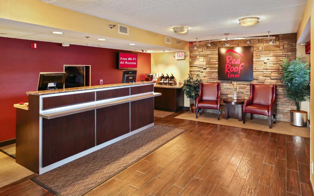 a bar in a restaurant with red walls and chairs at Red Roof Inn Johnson City in Johnson City