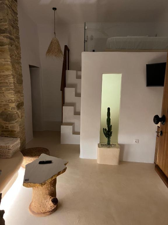 a room with a cactus and a table and stairs at Nature Friendly Dame in Mési