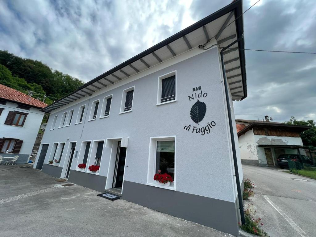 ein weißes Gebäude mit einem Schild an der Seite in der Unterkunft Nido di Faggio 