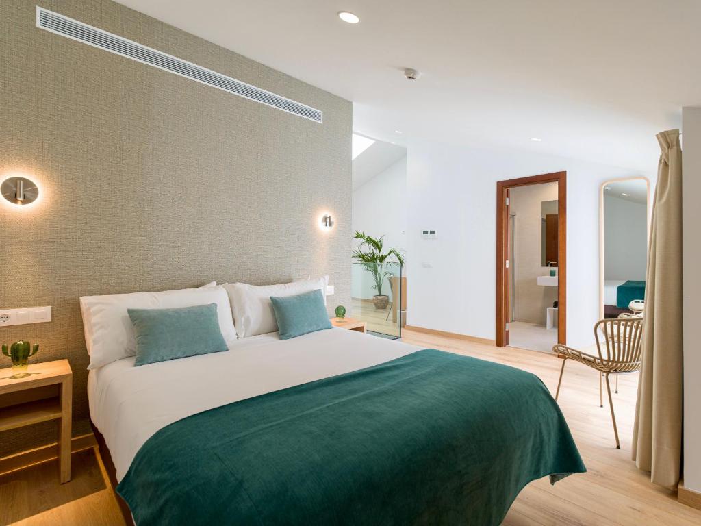 - une chambre avec un grand lit et une couverture verte dans l'établissement Hotel Emeté & Coworking, à Las Palmas de Gran Canaria