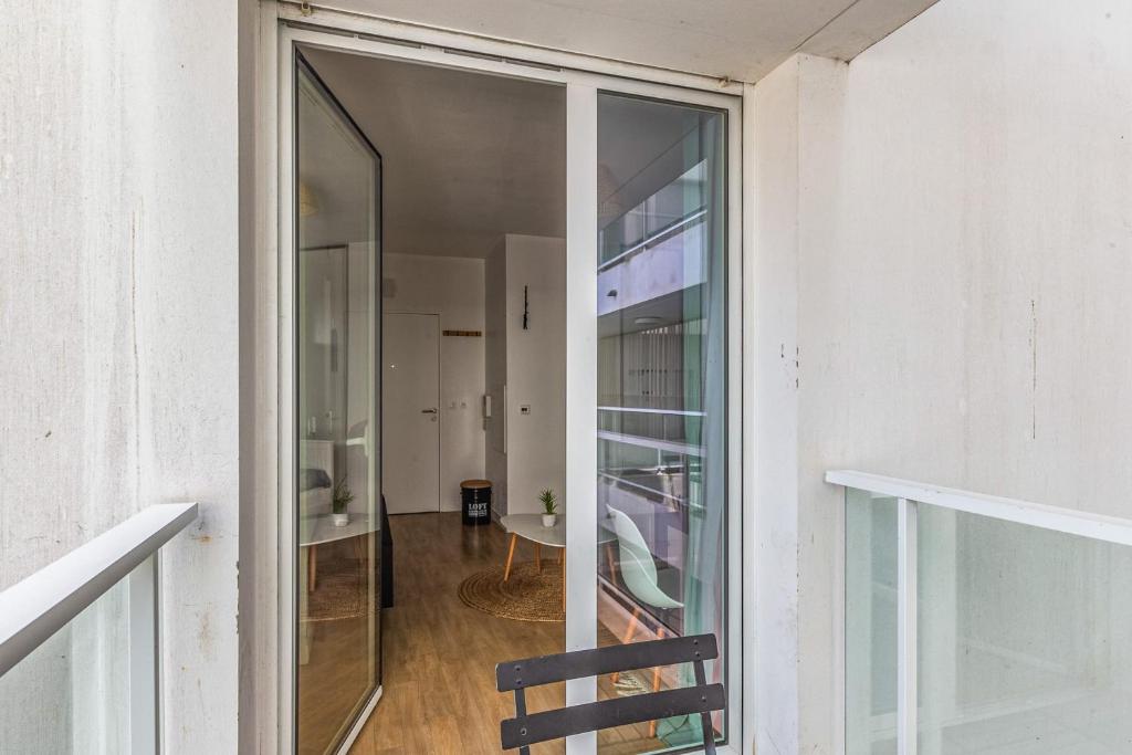 a glass door leading into a room with a table at Nice and cozy studio with balcony - La Rochelle - Welkeys in La Rochelle