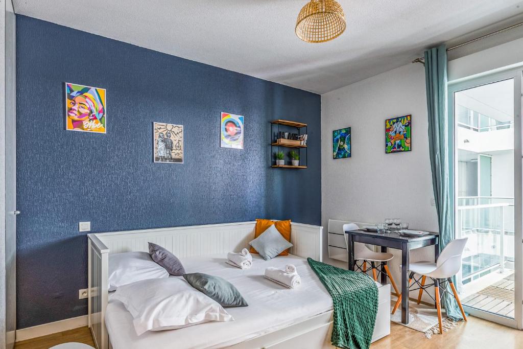 a bedroom with a white bed and a blue wall at Nice and cozy studio with balcony - La Rochelle - Welkeys in La Rochelle