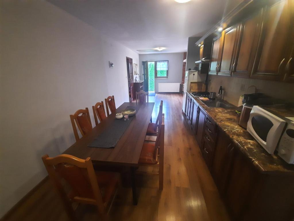 POKOJE RODIS في اوسترزوكي دولن: مطبخ مع طاولة وكراسي خشبية طويلة