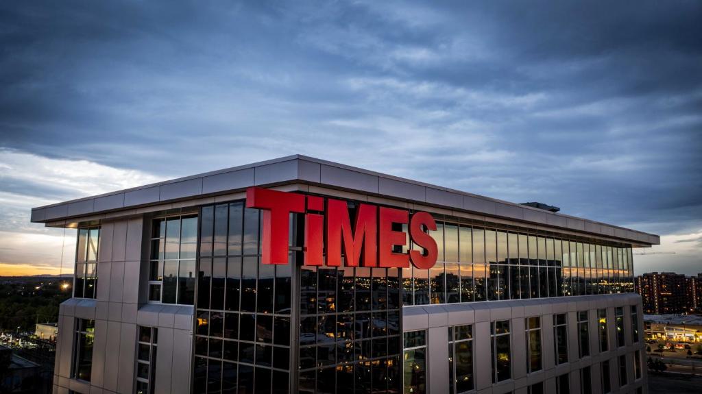 a building with a times sign on the top of it at Grand Times Hotel Laval - Centropolis in Laval