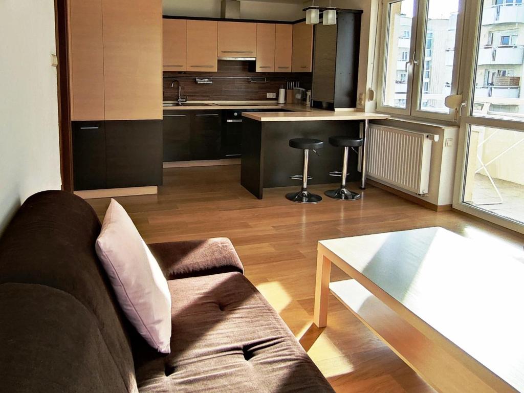 a living room with a couch and a kitchen at Apartament F&J #12 in Toruń