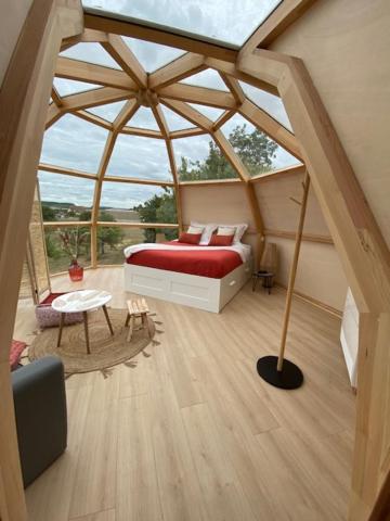 a room with a bed and a large window at Nuit’s Féerique en Champagne in Meurville