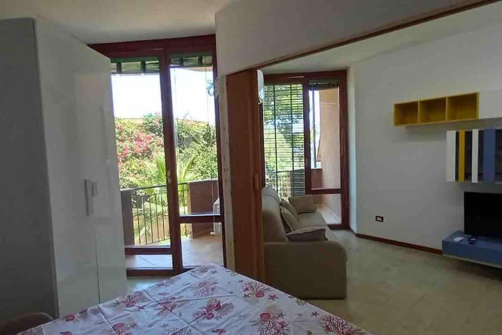 1 dormitorio con cama y vistas a un balcón en Gli appartamenti di Francuzzo, en Teulada