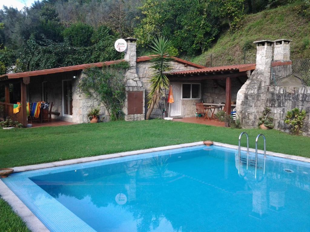 a swimming pool in front of a house at Quinta do Jaco in Vieira do Minho