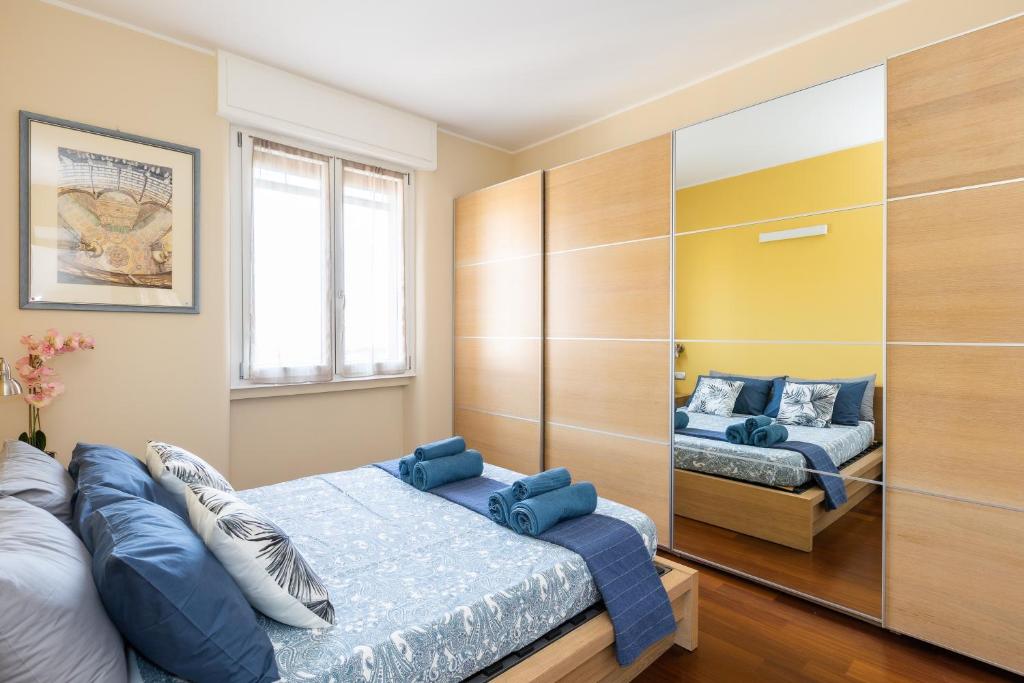 1 dormitorio con 2 camas y almohadas azules en Rosselli 13 Milan Apartment, en Milán