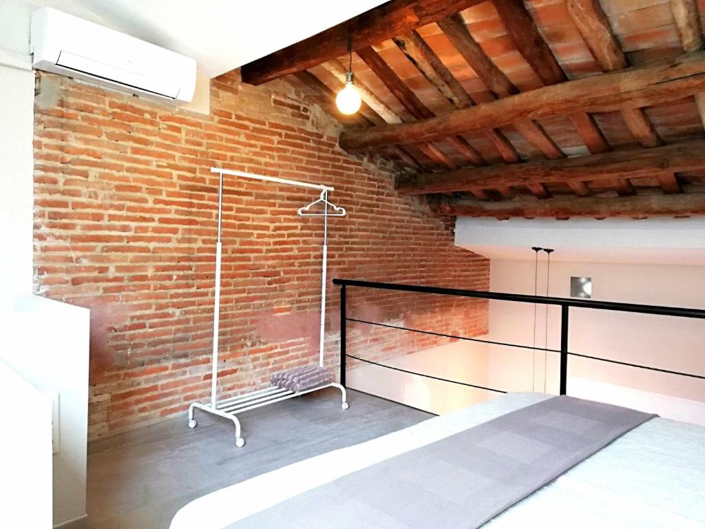 a room with a brick wall and a bed in it at Mazi Apartments Penthouse in Badalona