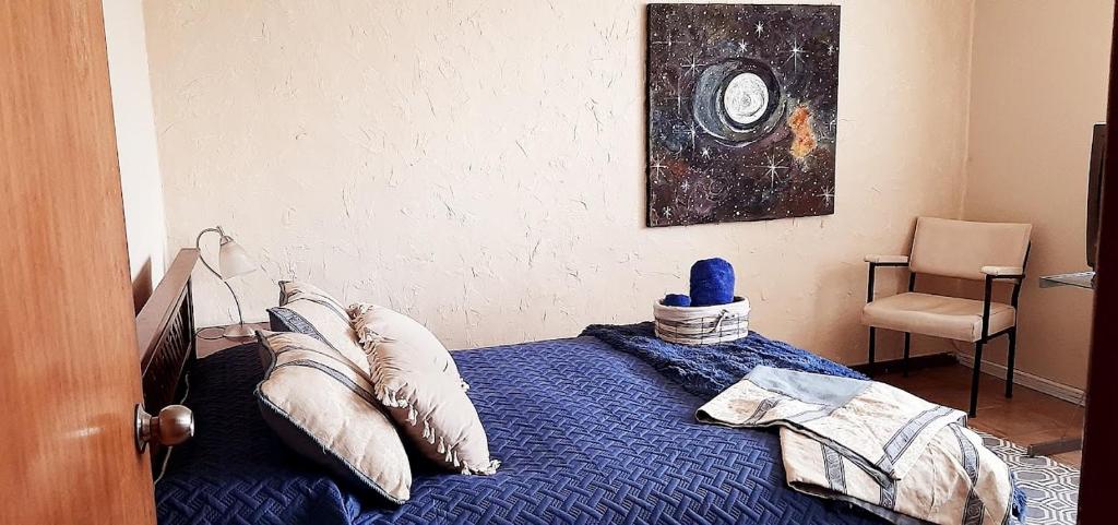 een slaapkamer met een bed met een blauw dekbed bij JI Home Boutique in Santiago