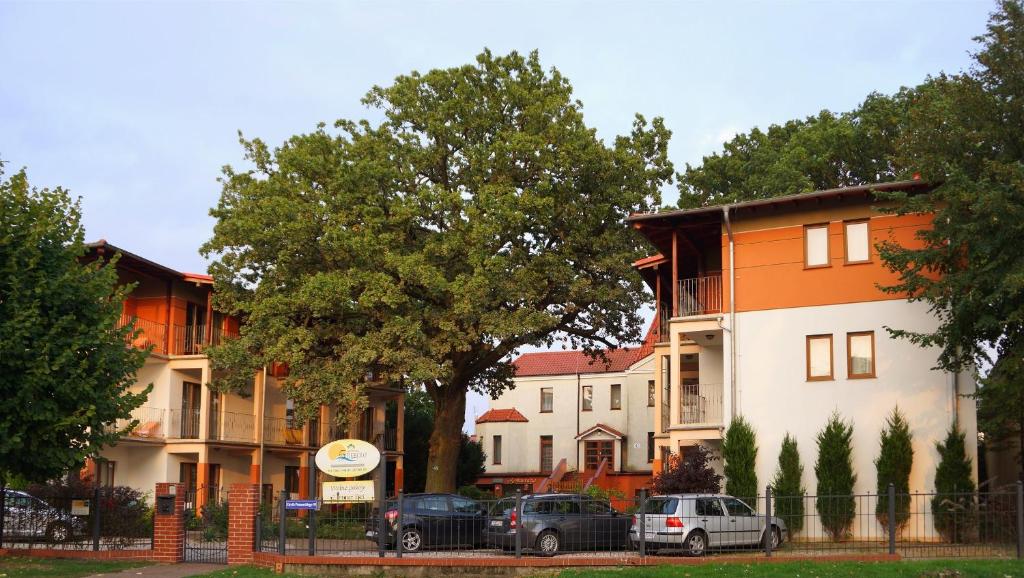 a row of houses with cars parked in front of them at Rezydencja 5 Dębów in Międzyzdroje