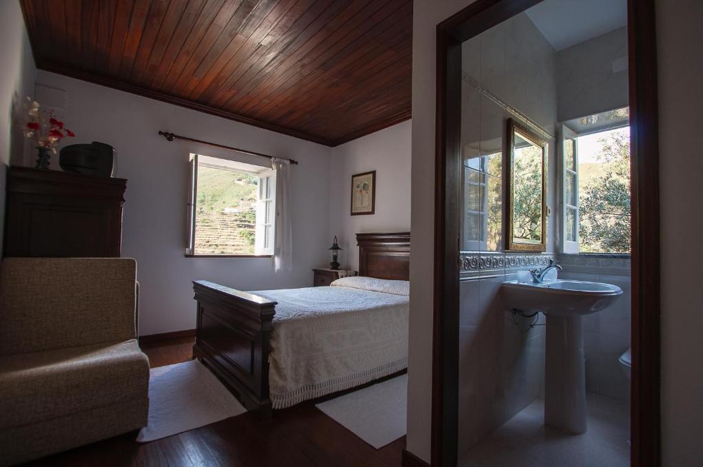 a bedroom with a bed and a sink and a mirror at Casa da Padaria in Piódão