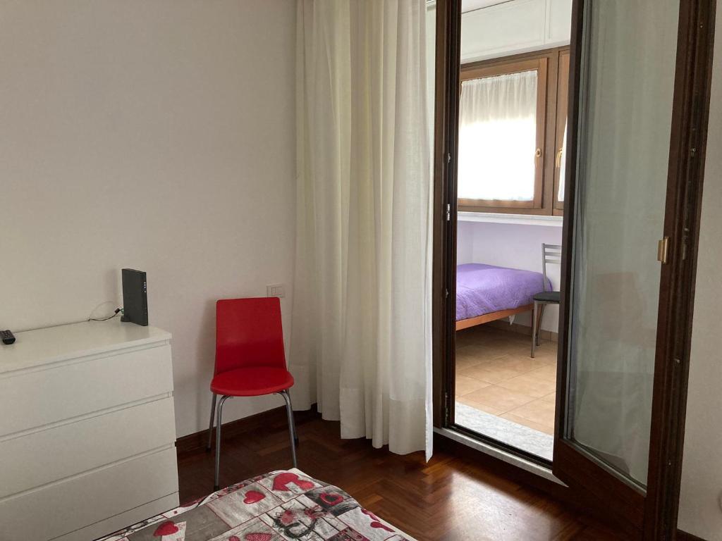 een slaapkamer met een rode stoel en een spiegel bij Da Sofia apartment-parking in Cagliari