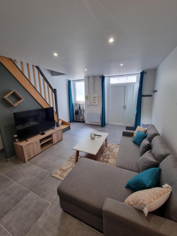 ein Wohnzimmer mit einem Sofa und einem TV in der Unterkunft Superbe logement T3 en duplex. in Saint-Gaudens