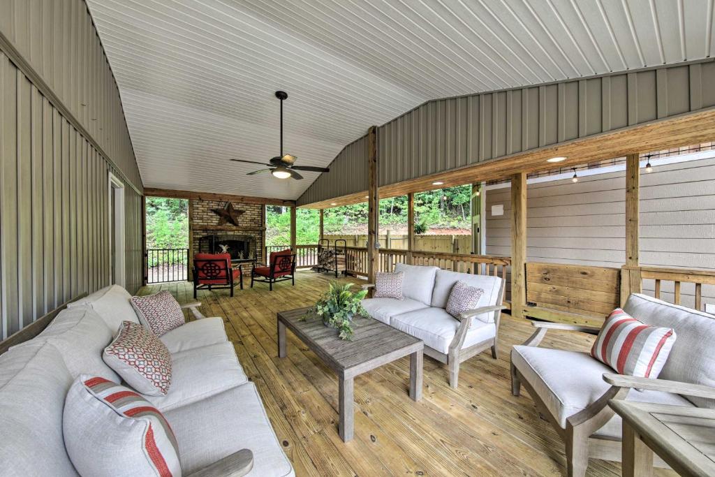a screened in porch with couches and a table at Blairsville Tiny Home with Covered Furnished Deck! in Blairsville